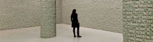 A woman looking at a Guggenheim art exibit where an entire room is wallpapered with 100,000 $1 bills.