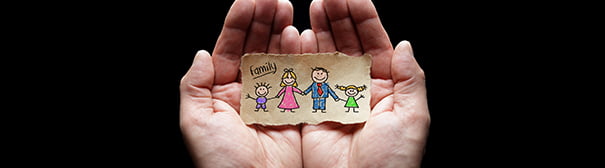 hands holding a picture of a family